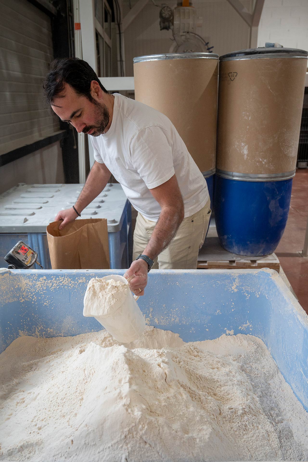 Remplissage manuel d’un sac de farine par Mathieu Choux, fondateur de la meunerie Gaston Meunier Bio, installée à Pierre-Bénite (métropole de Lyon)